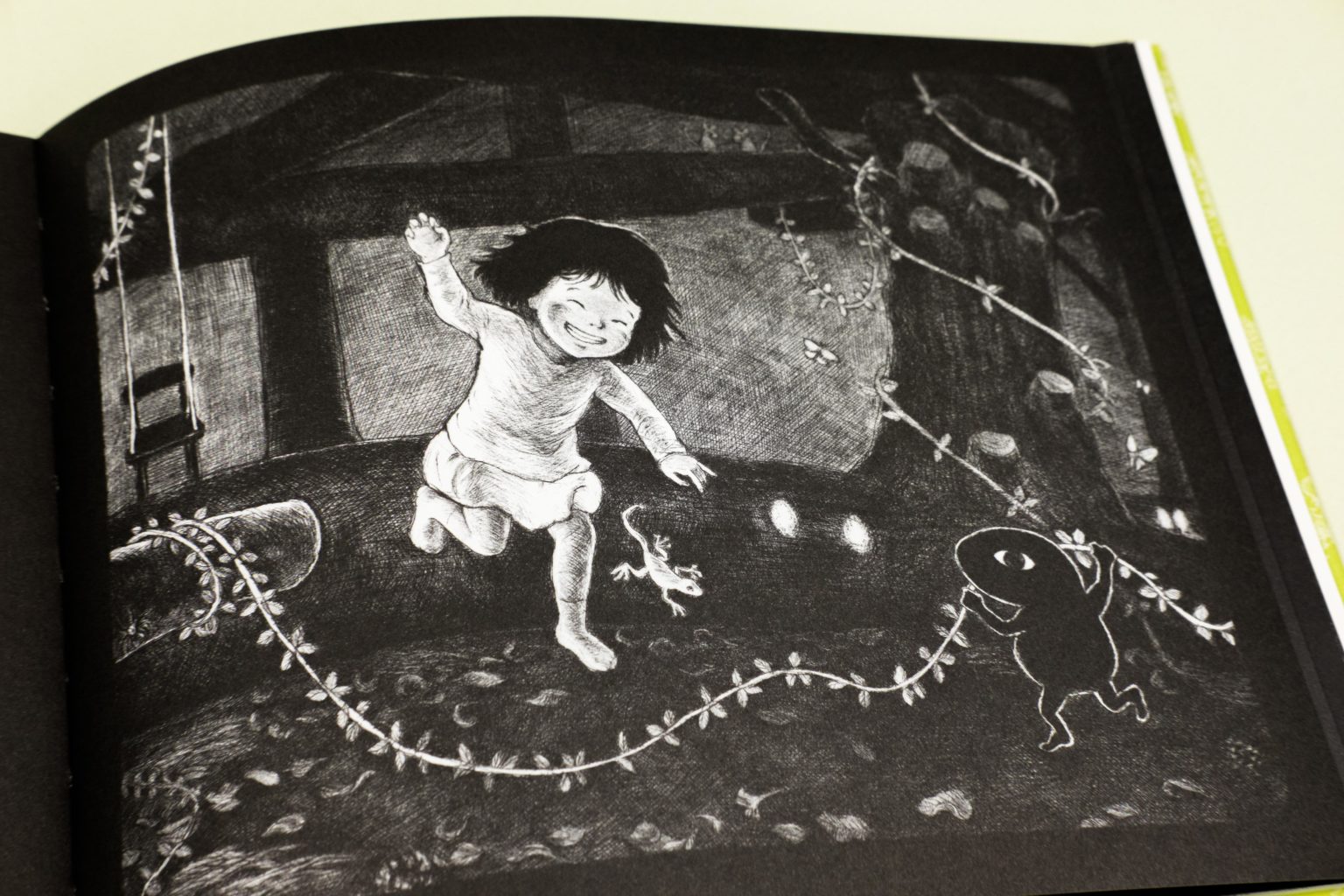 La petite fille du livre danse au milieu de guirlandes avec sa nouvelle amie, la petite chose noire